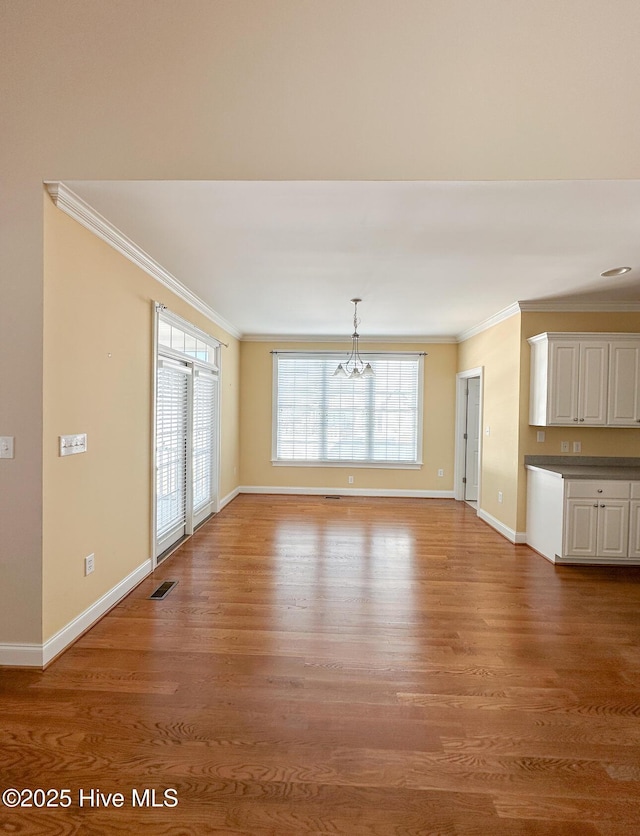 unfurnished living room with crown molding and wood-type flooring