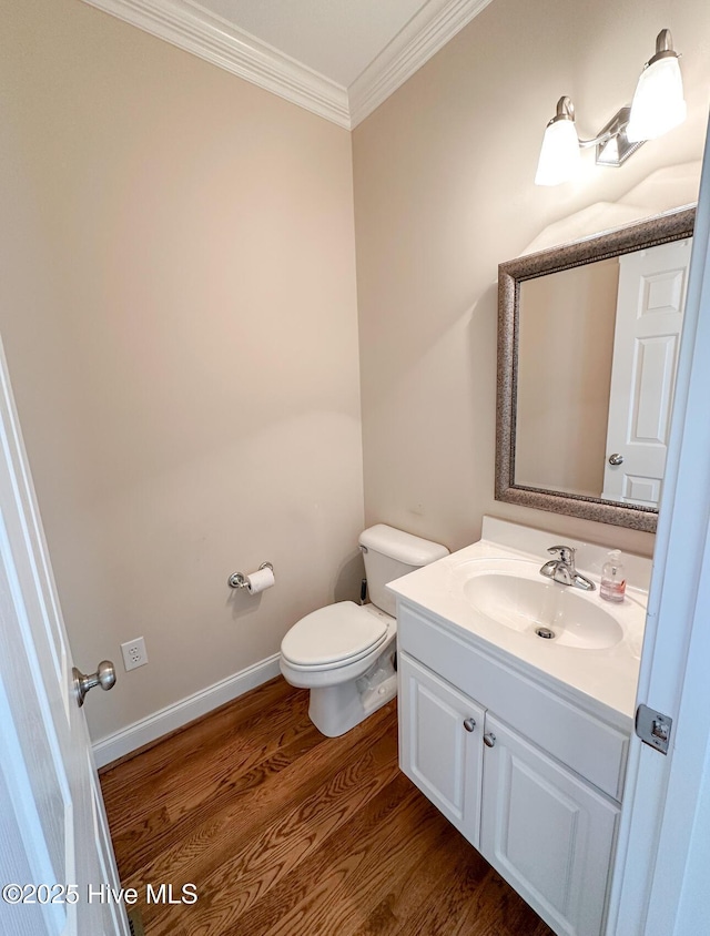 bathroom with ornamental molding, hardwood / wood-style floors, vanity, and toilet