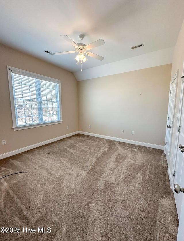 spare room featuring ceiling fan, lofted ceiling, and carpet flooring