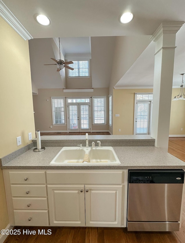 kitchen with sink, dishwasher, kitchen peninsula, ceiling fan, and white cabinets