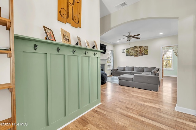 living room with ceiling fan and light wood-type flooring