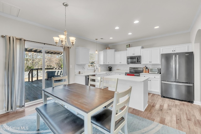 dining room featuring ornamental molding, sink, and light hardwood / wood-style floors