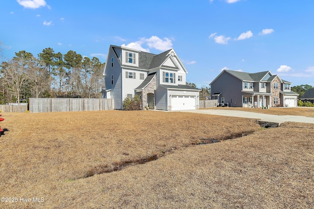 view of property featuring a garage and a front lawn