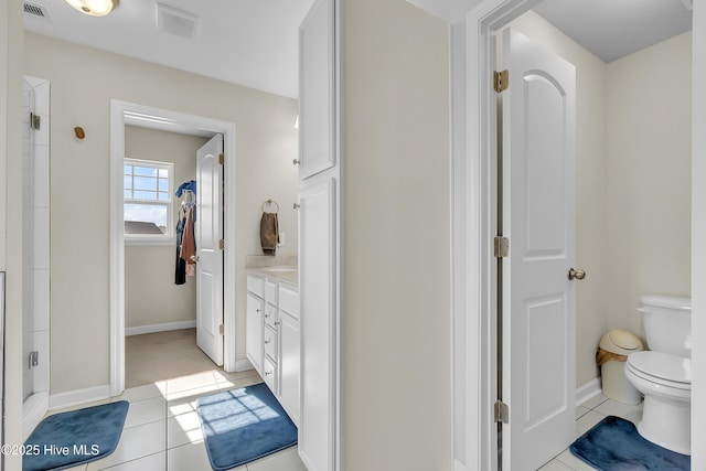 bathroom with tile patterned flooring, vanity, walk in shower, and toilet