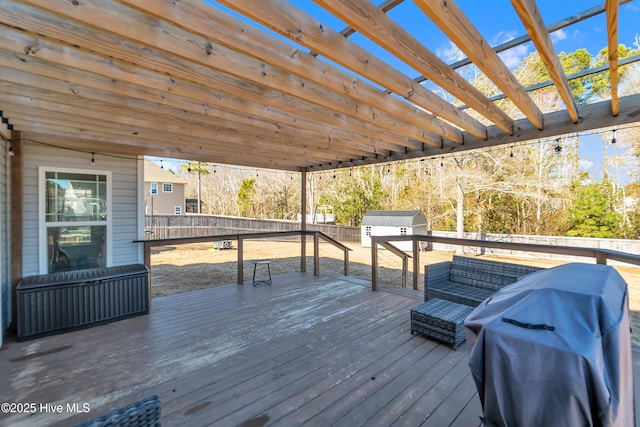 wooden terrace featuring area for grilling and a shed