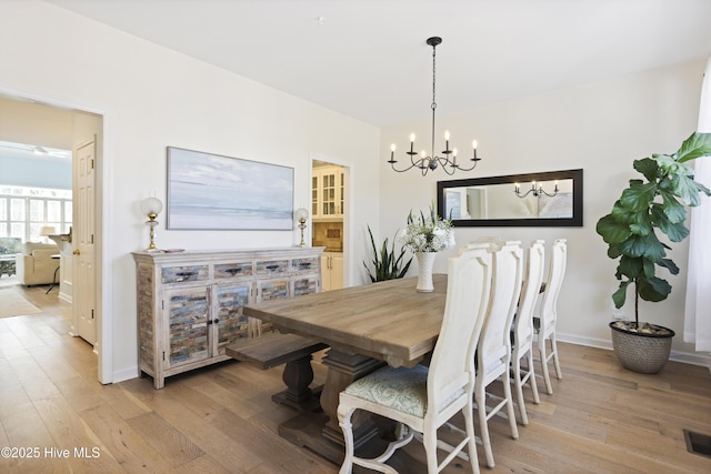 dining room featuring an inviting chandelier and light wood-type flooring