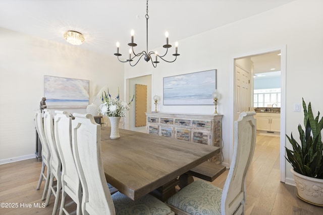 dining area with a chandelier and light hardwood / wood-style flooring