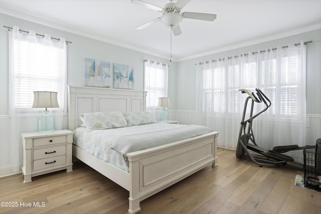 bedroom with ornamental molding, ceiling fan, and light hardwood / wood-style flooring