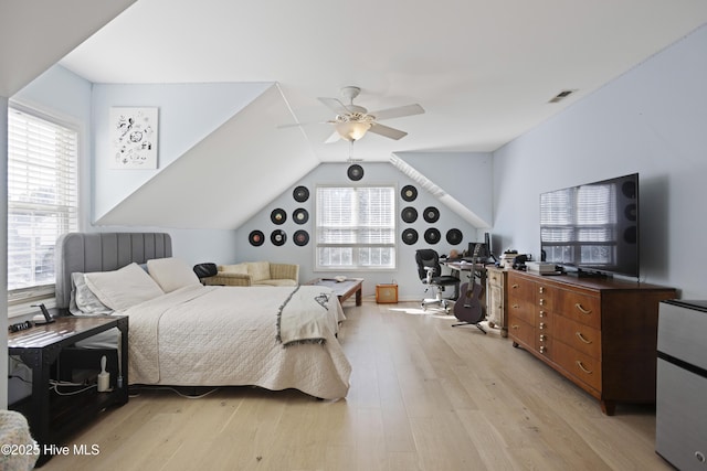 bedroom featuring ceiling fan, lofted ceiling, multiple windows, and light wood-type flooring