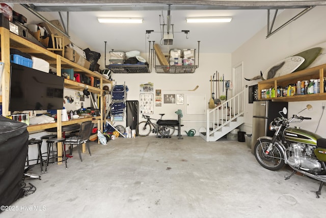 garage featuring stainless steel refrigerator and a workshop area