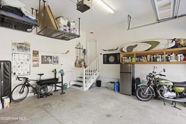 garage with a garage door opener and stainless steel fridge