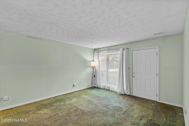 carpeted empty room featuring a textured ceiling