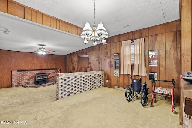 interior space with carpet flooring, wooden walls, a notable chandelier, and a textured ceiling