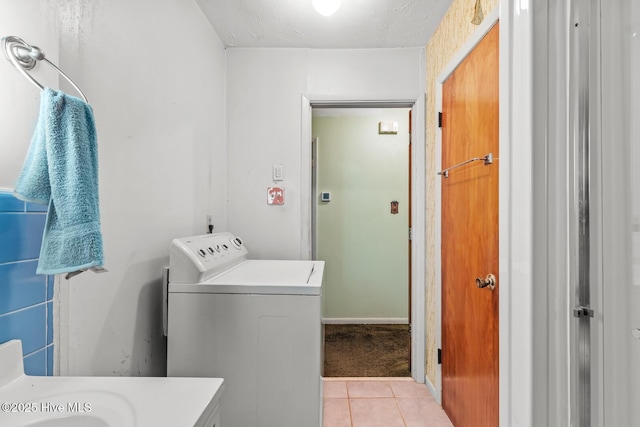 laundry room featuring light tile patterned flooring, washer / dryer, and a textured ceiling