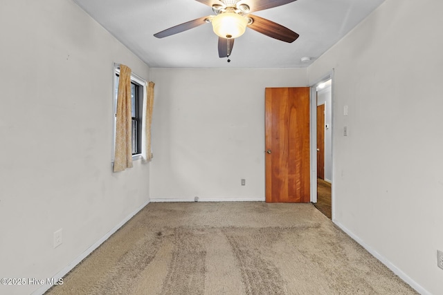 carpeted spare room featuring ceiling fan