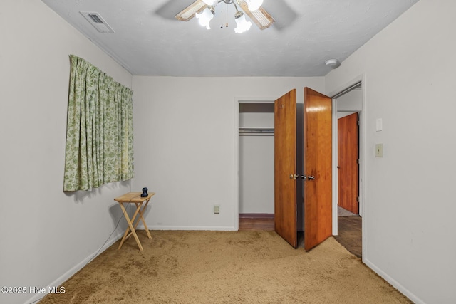 carpeted bedroom with ceiling fan and a closet