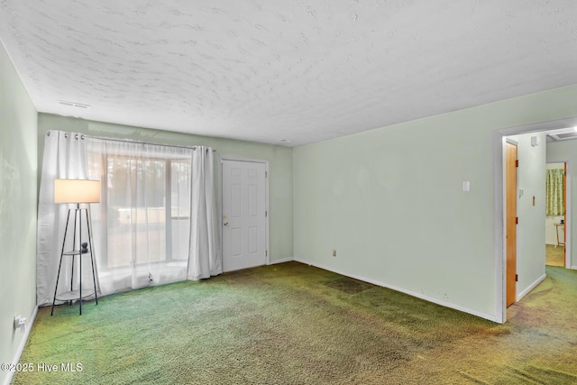 carpeted spare room featuring a textured ceiling