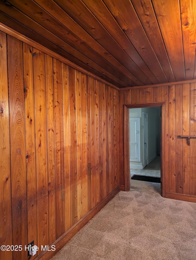 interior space featuring light colored carpet, wooden ceiling, and wood walls