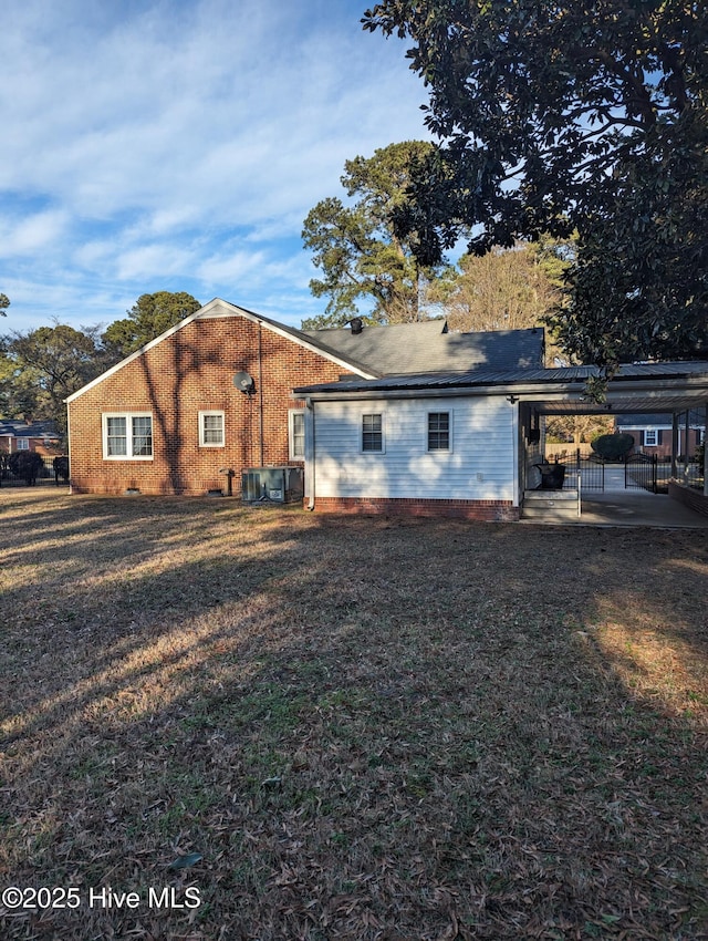 back of house with a yard and central AC unit