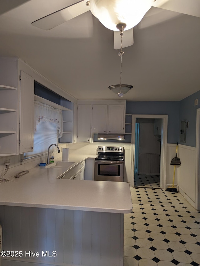 kitchen with white cabinets, sink, electric range, and kitchen peninsula