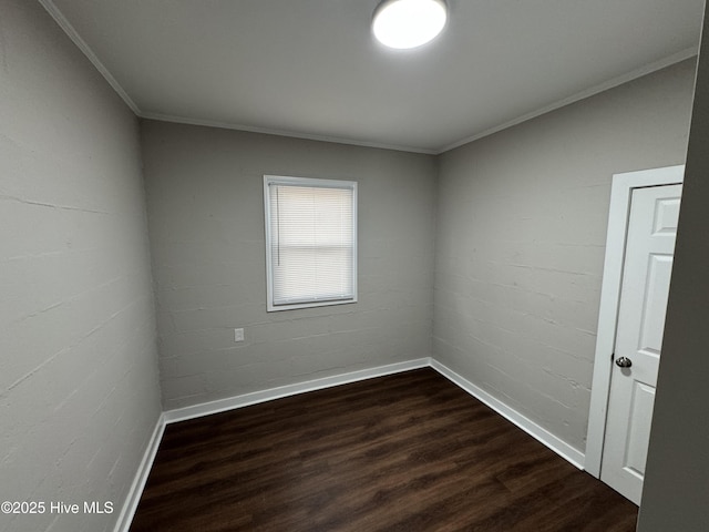 unfurnished room featuring dark hardwood / wood-style flooring, crown molding, and brick wall