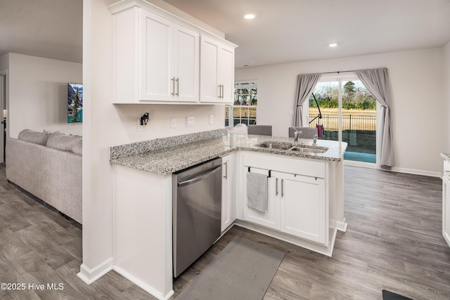 kitchen with hardwood / wood-style floors, dishwasher, sink, white cabinets, and kitchen peninsula