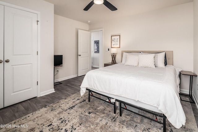 bedroom featuring dark wood-type flooring, a closet, and ceiling fan