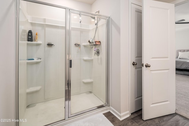 bathroom featuring wood-type flooring and a shower with shower door