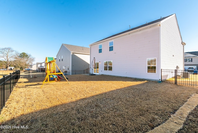 back of house featuring a playground and a yard