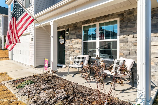 entrance to property featuring a porch and a garage