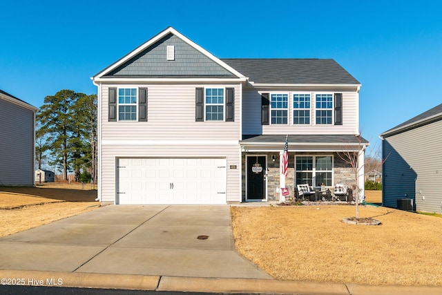 view of front of house featuring a porch, a garage, and a front lawn