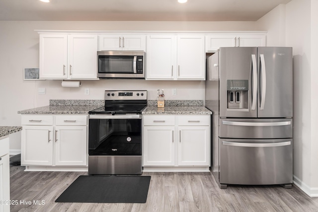 kitchen featuring light stone counters, white cabinetry, and appliances with stainless steel finishes