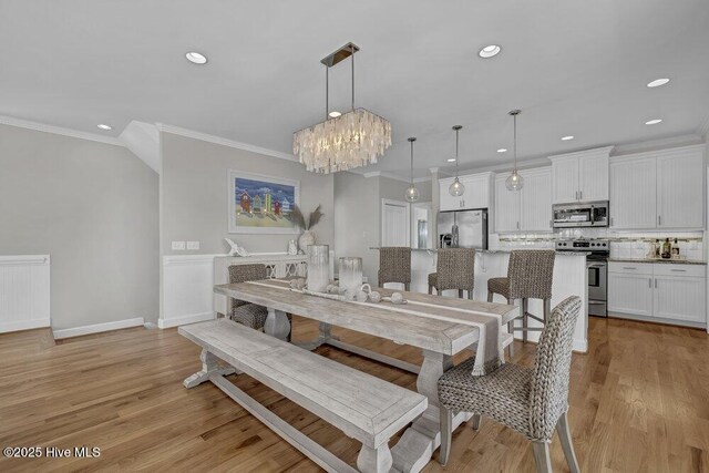 living room featuring ceiling fan, ornamental molding, and light hardwood / wood-style flooring