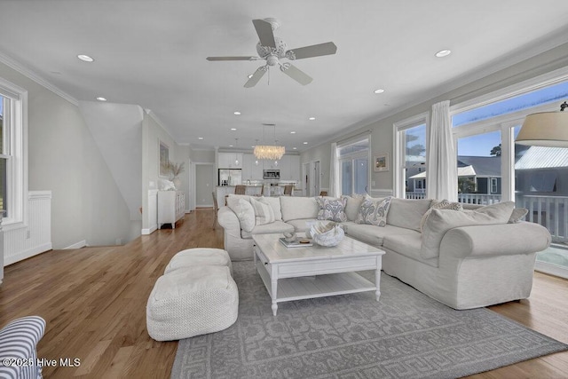 living room with ornamental molding, recessed lighting, and light wood finished floors