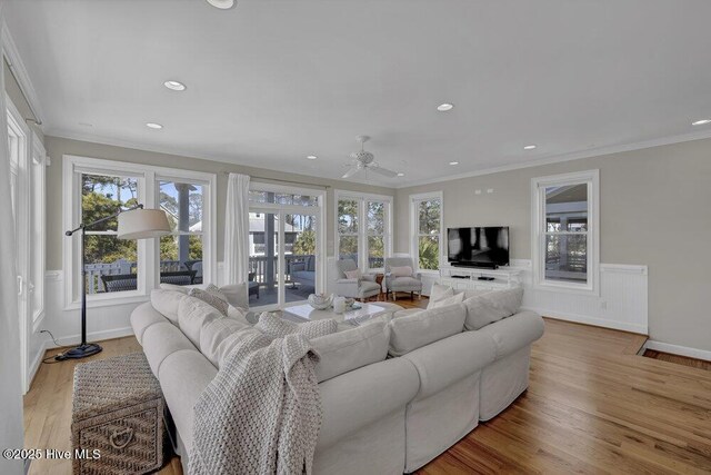 living room with crown molding, ceiling fan, plenty of natural light, and light hardwood / wood-style flooring