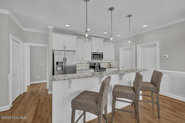 dining space featuring a notable chandelier, ornamental molding, and light wood-type flooring