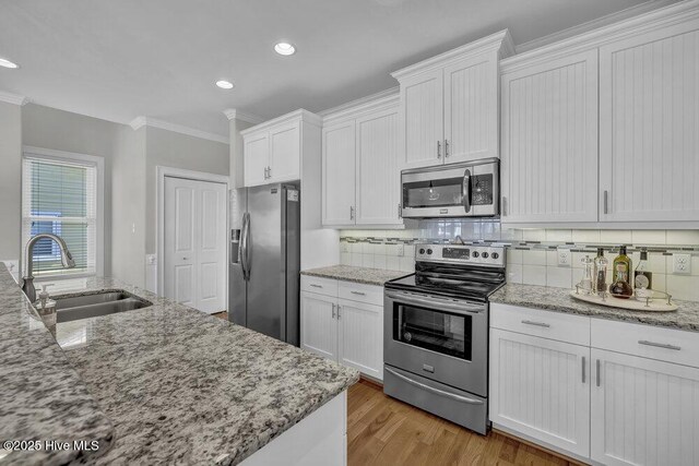 kitchen featuring white cabinetry, appliances with stainless steel finishes, sink, and a breakfast bar