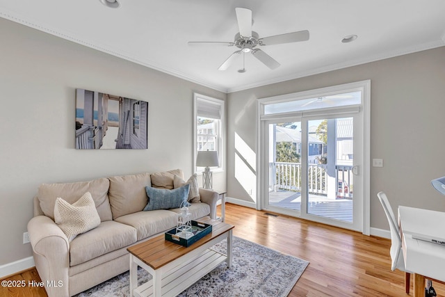 living room with crown molding, ceiling fan, and light hardwood / wood-style flooring