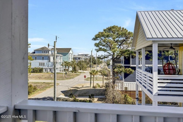 view of yard featuring a residential view, a balcony, and a ceiling fan