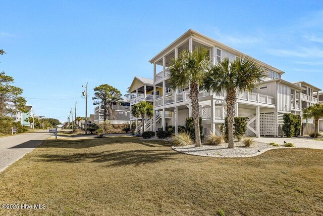 beach home with a garage, a balcony, and a porch