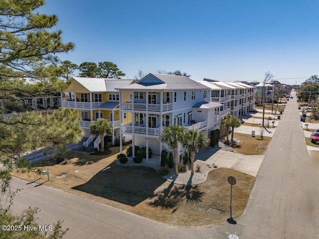 view of front of house with driveway, a residential view, and a balcony