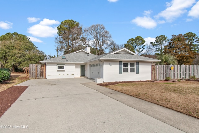 single story home with a chimney, an attached garage, fence, driveway, and a front lawn