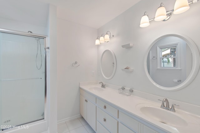 bathroom with tile patterned flooring, double vanity, a sink, and an enclosed shower