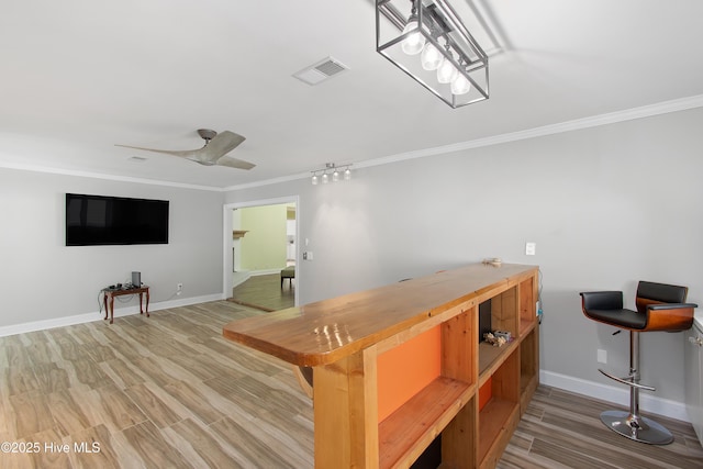 bar with baseboards, visible vents, ceiling fan, ornamental molding, and wood finished floors