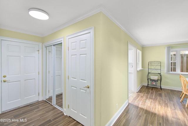 corridor featuring baseboards, ornamental molding, and dark wood finished floors