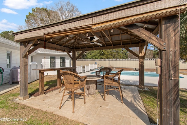 view of patio / terrace with a gazebo, outdoor dining space, a fenced backyard, and a fenced in pool