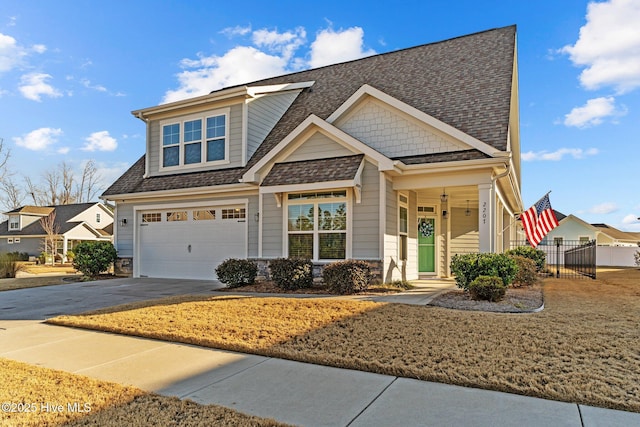 craftsman inspired home with driveway, an attached garage, and roof with shingles