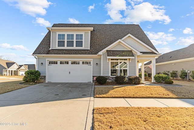 craftsman-style house with driveway, a shingled roof, and an attached garage