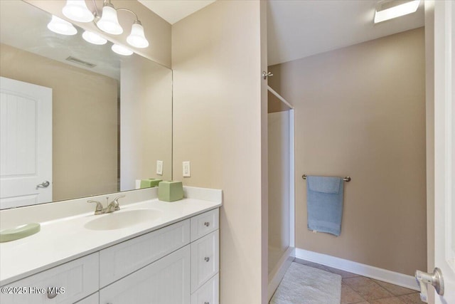 bathroom featuring tile patterned flooring, vanity, an inviting chandelier, and walk in shower