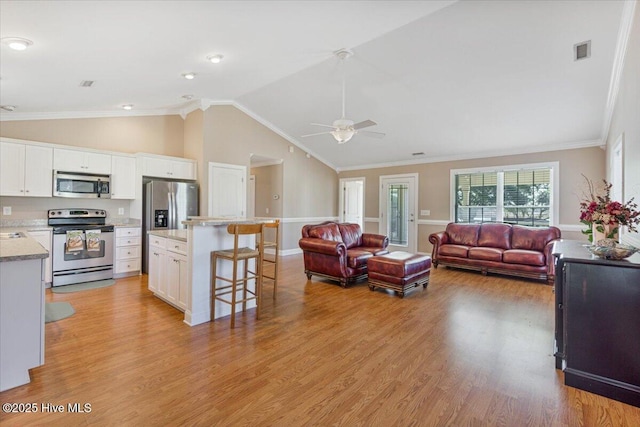 living room with ornamental molding, vaulted ceiling, ceiling fan, and light hardwood / wood-style floors